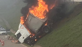 Carreta sai da pista, cai em canteiro e pega fogo na BR-381, em Barão de Cocais