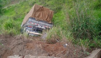 Motorista fica ferido após caminhão atingir carro e cair em ribanceira na MG-129, em Itabira